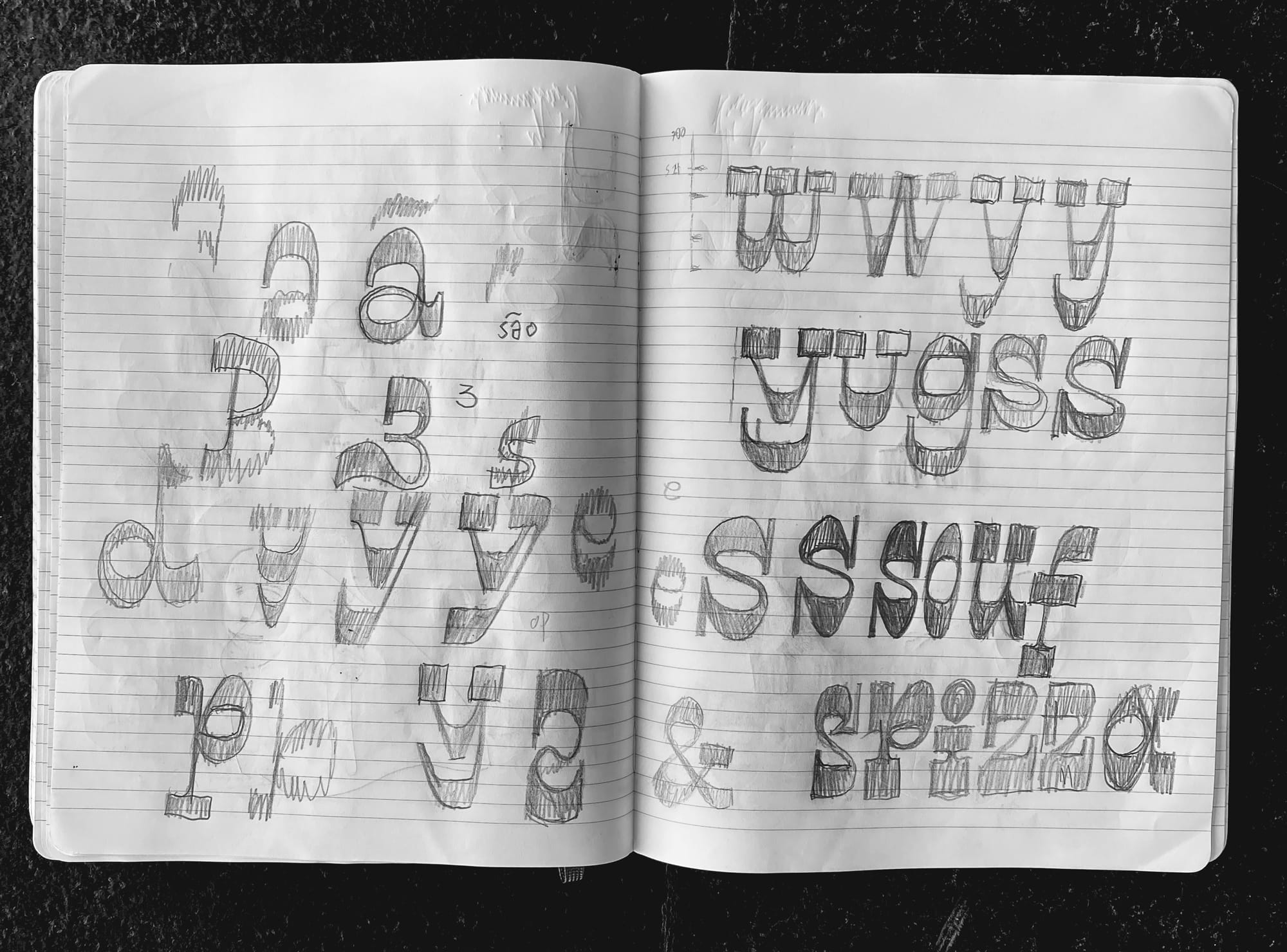 A sketchbook spread of Disco Cowboy letterform studies in pencil, whole alphabets worked out across two pages, including an ampersand.